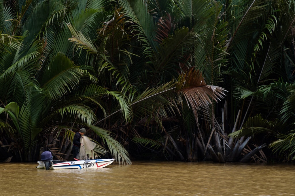 A fisherman prepares to cast his rambat net.