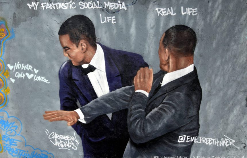 Graffiti of Will Smith slapping Chris Rock at the Oscars 2022 by Eme Freethinker at Mauerpark in Berlin, Germany. @Singlespeedfahrer / Wikimedia Commons / CC0 1.0