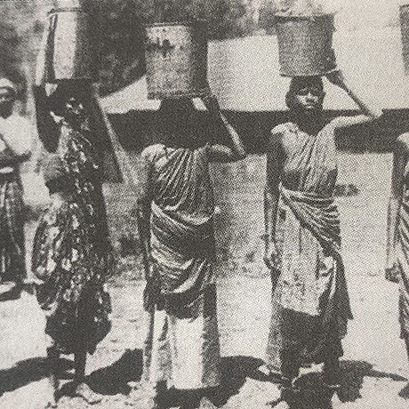 Female Indian workers carrying pails of tapped latex to the factory, 1900